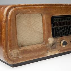 Old wooden radio with black dials.