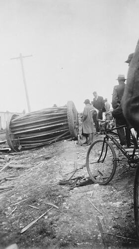 People viewing a cylindrical burst boiler. Bicycle in foreground.
