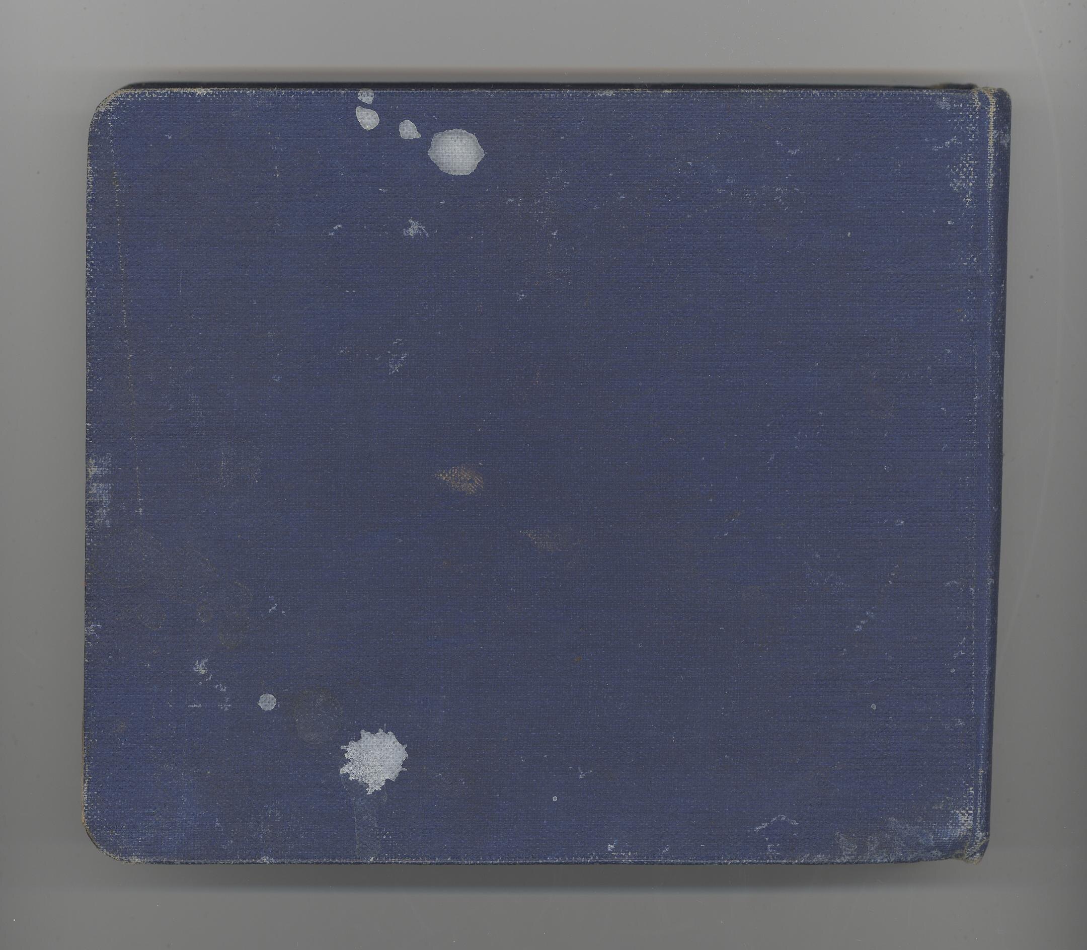 A vintage photograph album with a worn cover and pages containing old black and white photos.