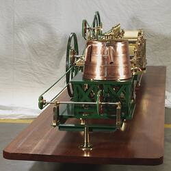Paper making machine miniature model made of metal. Detail of end with copper drum. Wooden base.