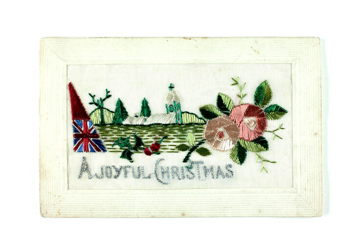 Front of embroidered postcard with country, flag and flowers.