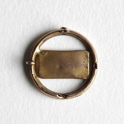Back of circular brooch showing metal welding.