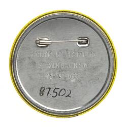 Back of round metal badge with horizontal pin.