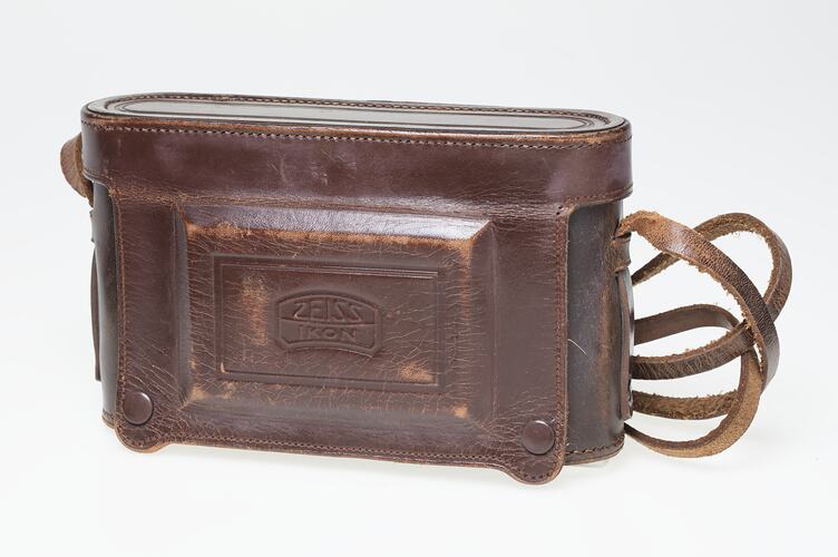 Brown leather camera case with strap.