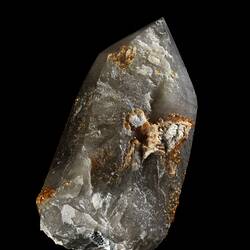 Blocky grey white prismatic crystal with orange staining.
