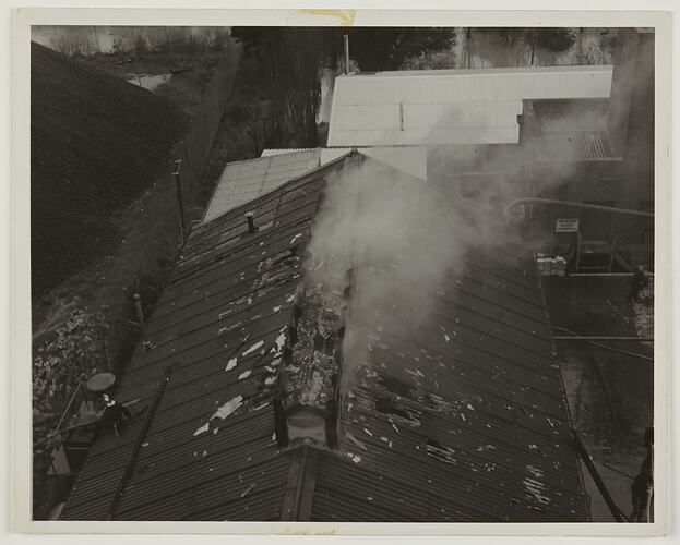 View from above of smoke coming out of a burning factory roof.