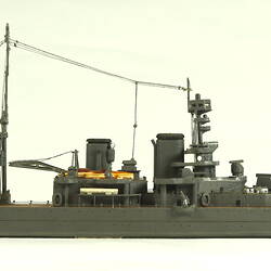 Naval ship with two masts, facing right.