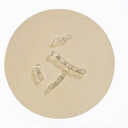 Light brown disc with clear glass capsule-shaped pieces on top.