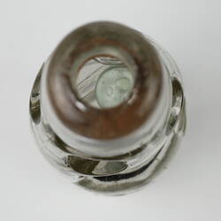 View downwards into mouth of clear glass bottle.