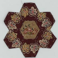 Brown floral hexagonal coloured fabric patches that are stitched together. Brown floral centre.