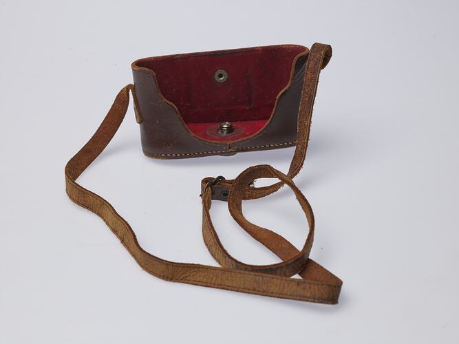 Brown leather camera case with strap. Red lining.