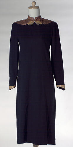 Black wool crepe dress, reptile skin decorative trim.