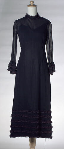 Long-sleeved black cotton dress with black lace.