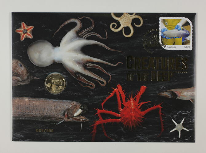 Multicoloured envelope depicting deep sea animals, with coin and stamp attached.