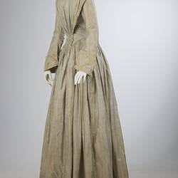 Pale grey striped silk dress with long sleeves and long skirt. Left front profile.