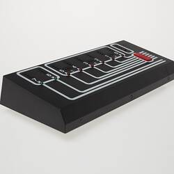 Rectangular black plastic computer control. White lines and lights on top.