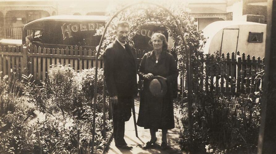 Digital Photograph - Holden Brothers Circus, Man & Woman Underneath Arch of Flowers, Front Gate of Home, Kensington, early 1930s