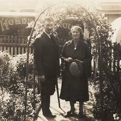 Digital Photograph - Holden Brothers Circus, Man & Woman Underneath Arch of Flowers, Front Gate of Home, Kensington, early 1930s