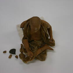 Slightly broken clay figure of a seated man.