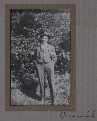 Man in suit standing in a garden.