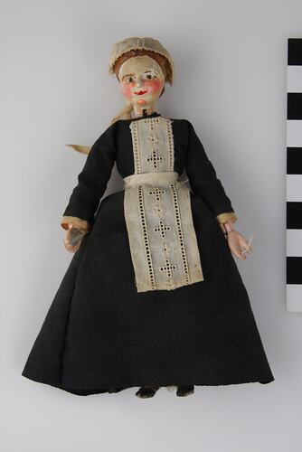 Wooden doll dressed in maid servant outfit.
