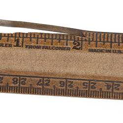 Wooden ruler with a slightly cracked section.