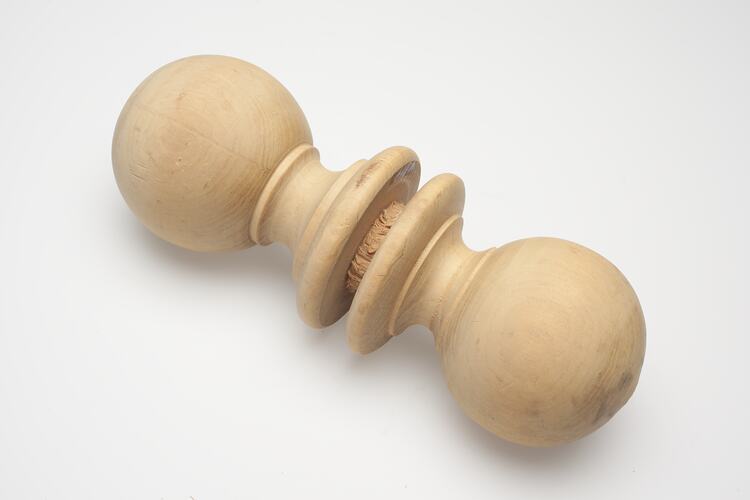 Two turned wooden knobs joined at their bases