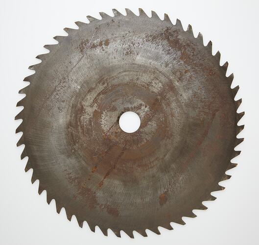 Metal circular saw blade with serrated edge and central hole.