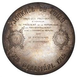 Round medal with engraved text.