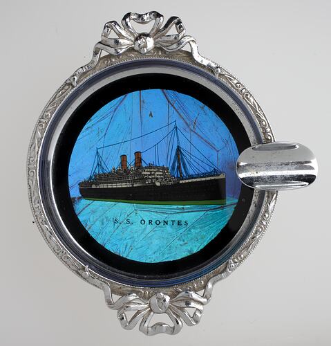 Silver ashtray with inlaid image of a ship.