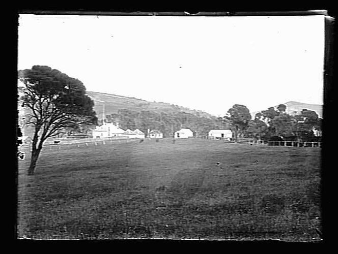 Field with buildings and hills in background.