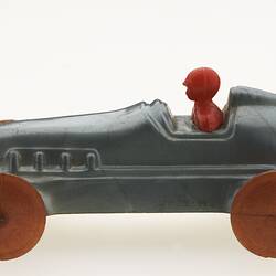 Silver racing car with red driver, left view.