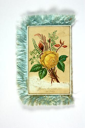 Christmas card with floral design and blue fringe.