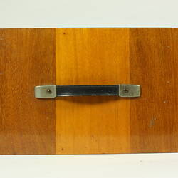 Top view of wooden box with black handle.