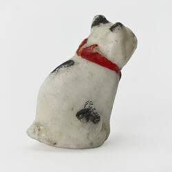 White cat figurine. Black spots and red collar. Right rear profile view.