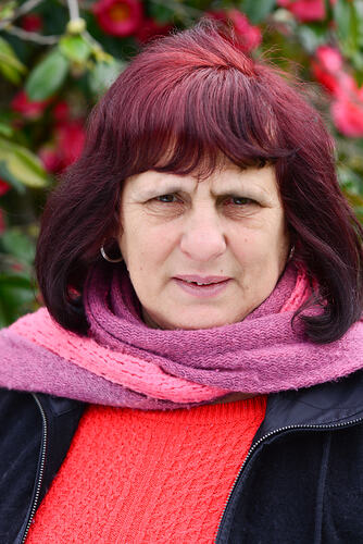 Woman wearing a pink scarf.