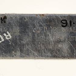 Metal plate with stamped text.