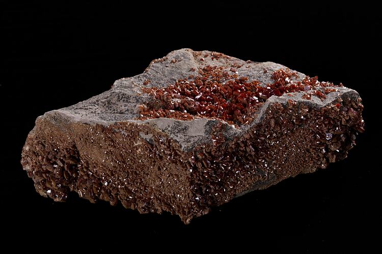 Red-orange crystals on grey rock.