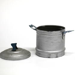 Side view of tiny aluminium pot with lid off.