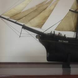 Detail of sailing ship model in glass case, facing left.
