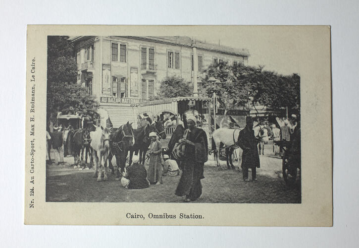 Building, people and horses in street.