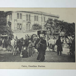 Building, people and horses in street.