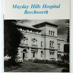 White booklet front cover. Features three-storey white building. Black and blue printed text.