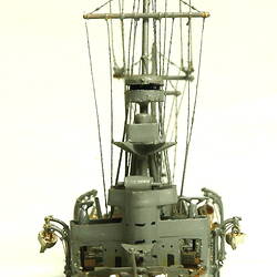 Naval ship with mast, front view.