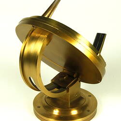 Three quarter view of gold metal chronometer.