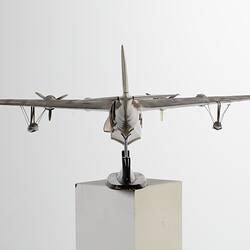 Green-silver model aeroplane on stand. Front view.