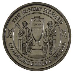 Round medal with cricketers each side of urn and text around edge.