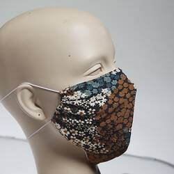 Face mask with floral design in brown, blue, black and white.