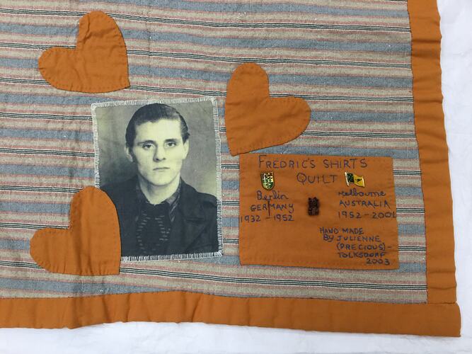 Detail of striped quilt. 3 sewn on hearts, fabric photo of man and patch with text.