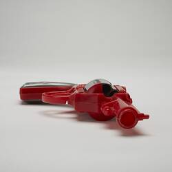 Red and grey plastic toy revolver, barrel view.